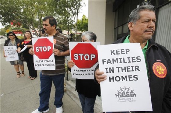 Demonstrators, whose homes are under foreclosure or lost their homes to foreclosure, holds signs during a foreclosure rally in front of JP Morgan Chase Bank in Oakland, Calif., Wednesday.